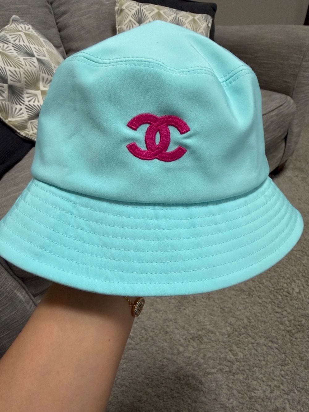 aqua blue bucket hat with pink emblem
